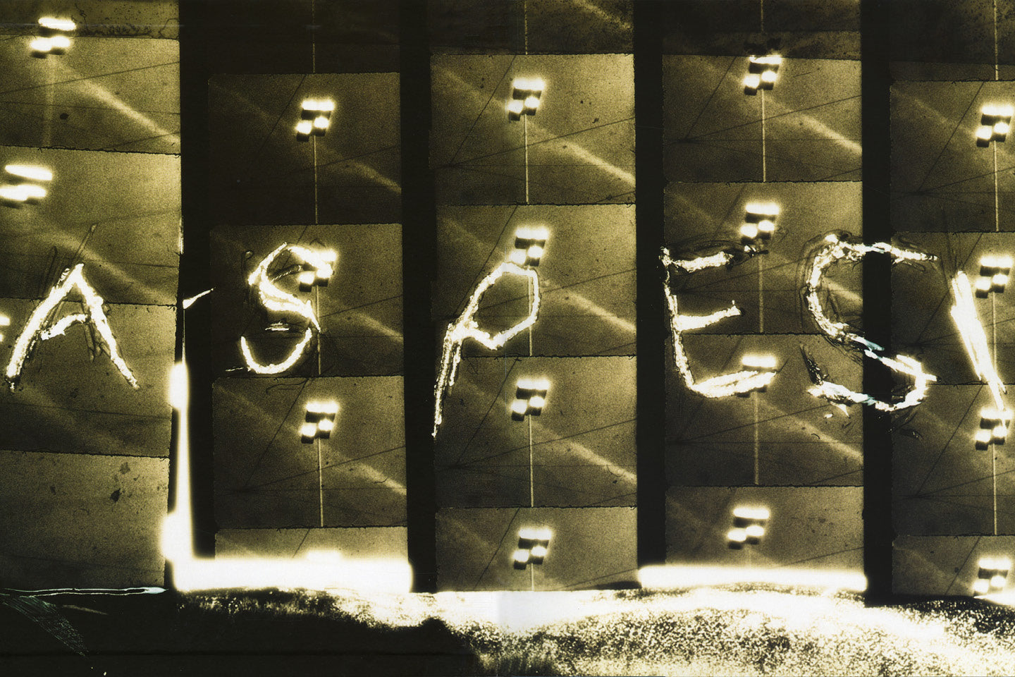Aspesi brand imagery: the word Aspesi picked out in illuminated letters across a concrete facade at night.